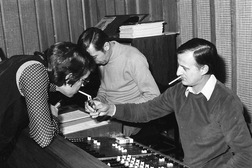 A man lights a cigarette in the ABC AM studios in 1977.