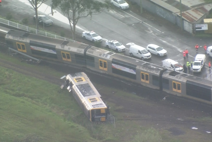 a train carriage on its side next to the track