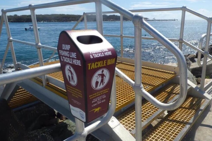 a bin that reads tackle bin next the ocean