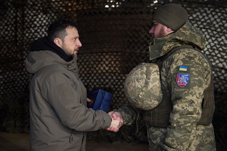 Volodymyr Zelenskyy awards a serviceman.