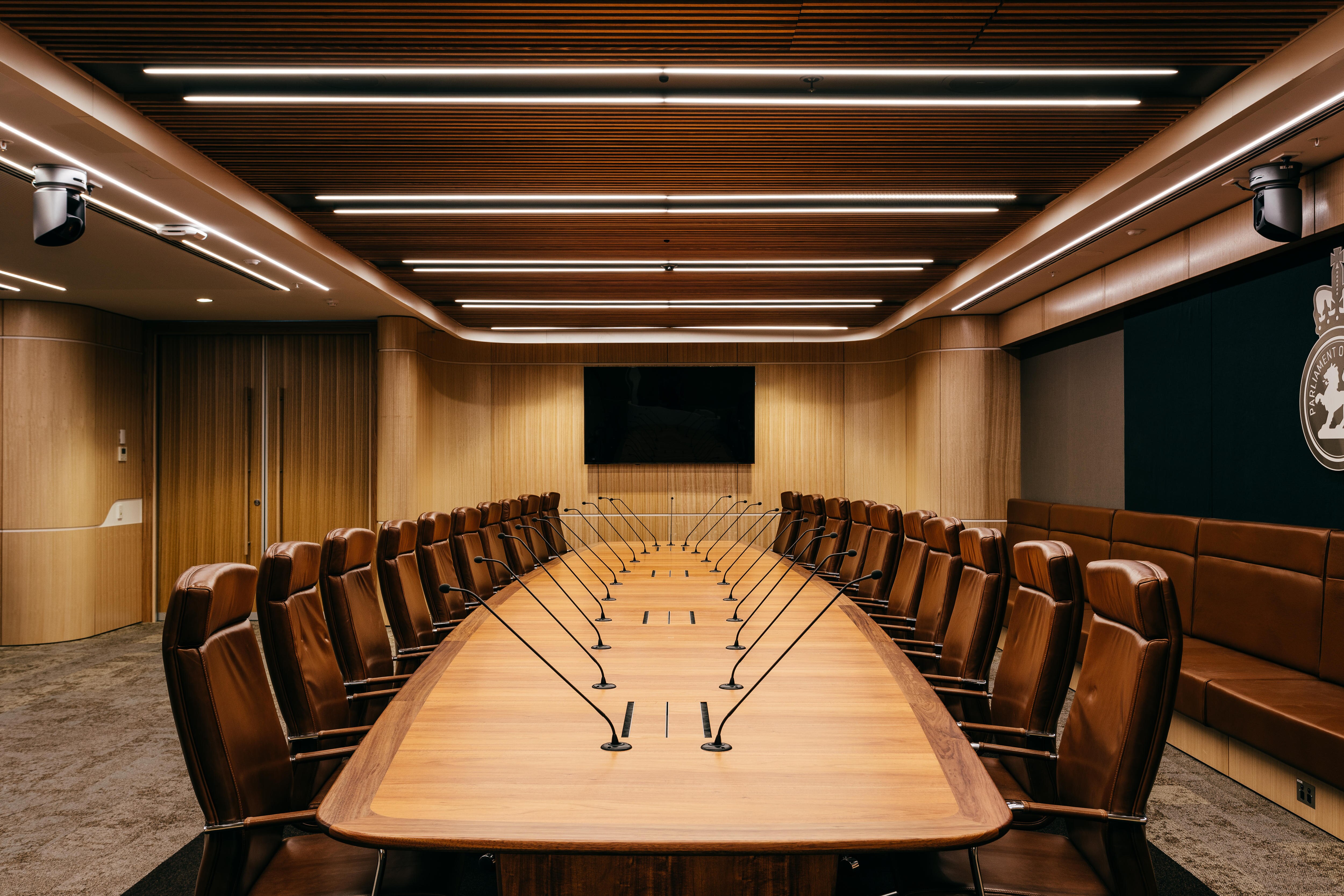 Large oval wood table surrounded by multiple leather chairs.