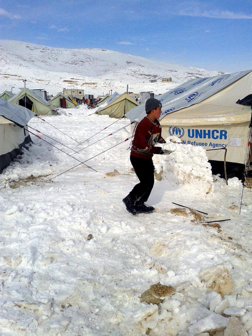A young Syrian plays with snow following a storm in the town of Arsal in the Lebanese Bekaa Valley.