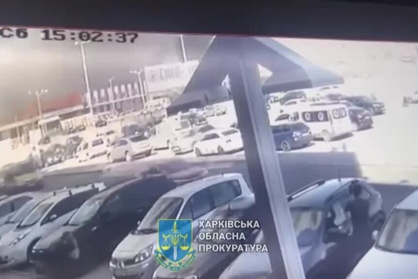 Screengrab from CCTV vision of cars in a busy parking lot. 