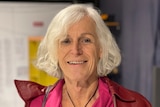 A smiling woman with shoulder length white hair