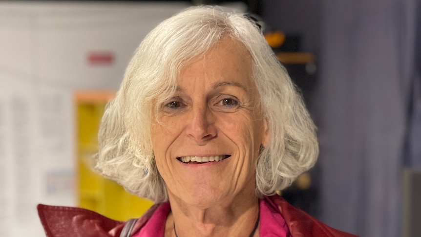 A smiling woman with shoulder length white hair