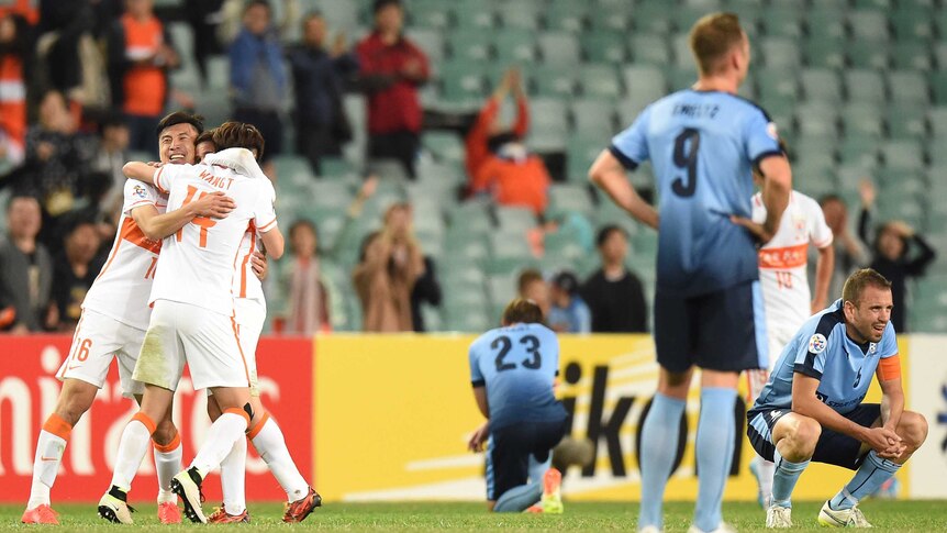 Shandong Luneng FC celebrate as disappointed Sydney FC players look on.