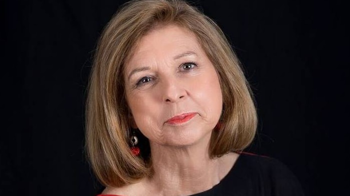 Bettina Arndt poses for a portrait, while wearing a red and black top