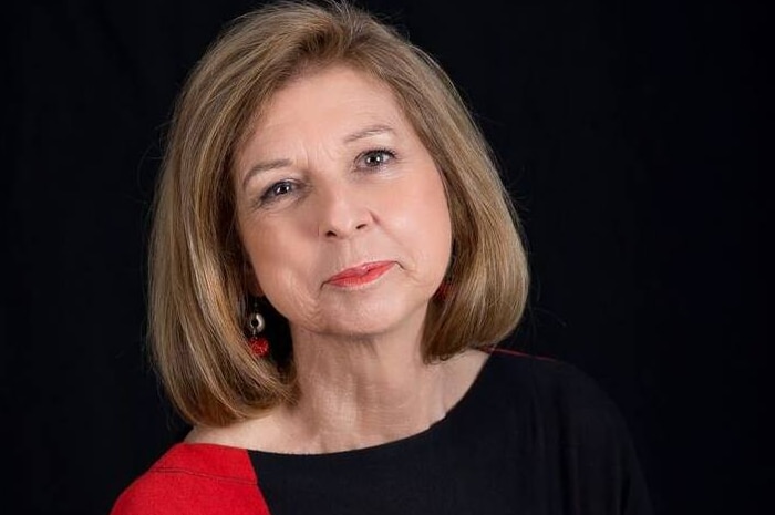 Bettina Arndt poses for a portrait, while wearing a red and black top