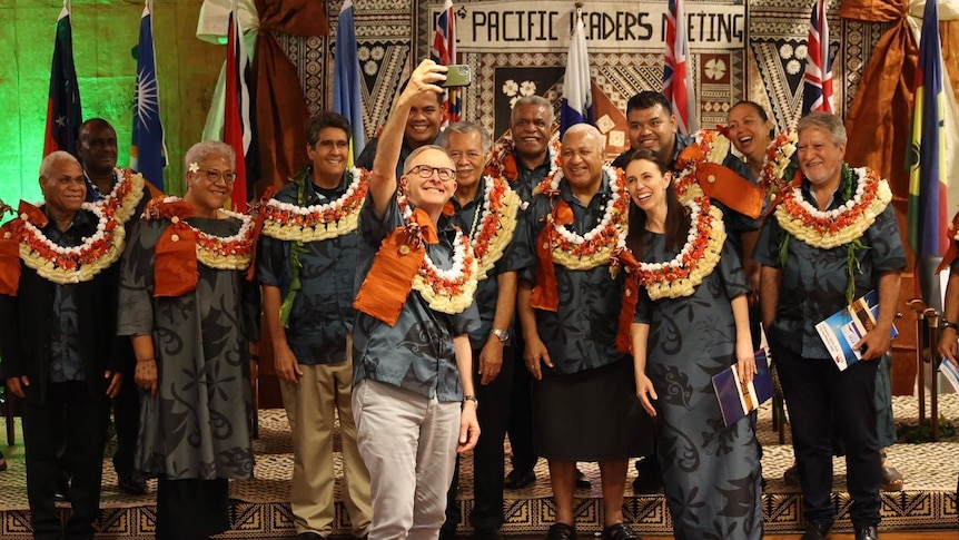 Prime Minister Anthony Albanese poses for a selfie with Pacific men and women wearing traditional Fijian salusalu garlands