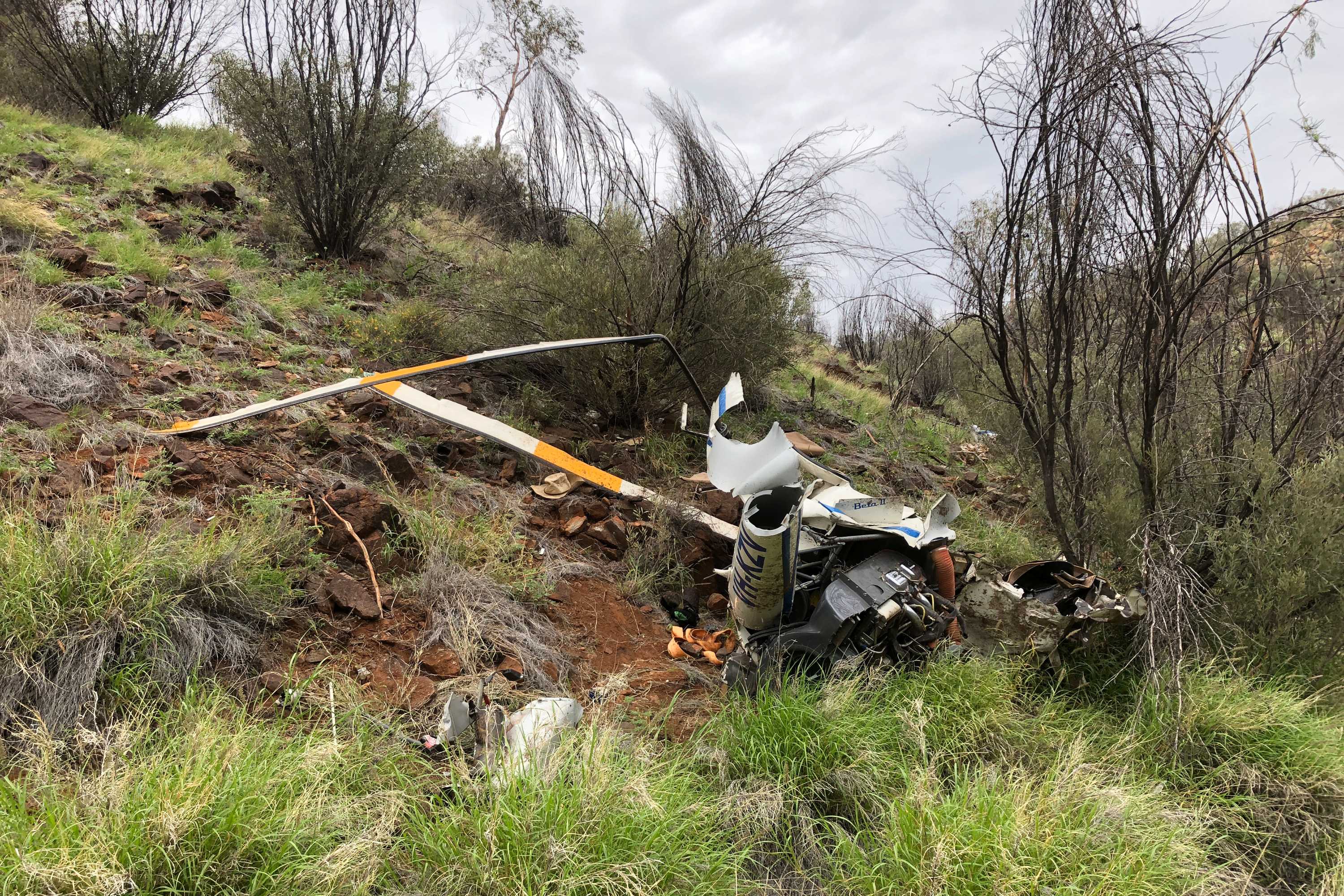 a wreck of a helicopter on the side of a hill.