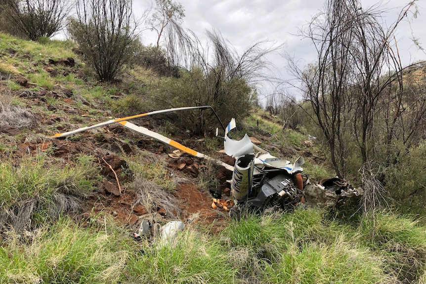 a wreck of a helicopter on the side of a hill.