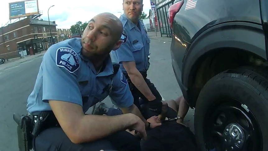 Two American police officers can be seen restraining a man, on body-cam footage.