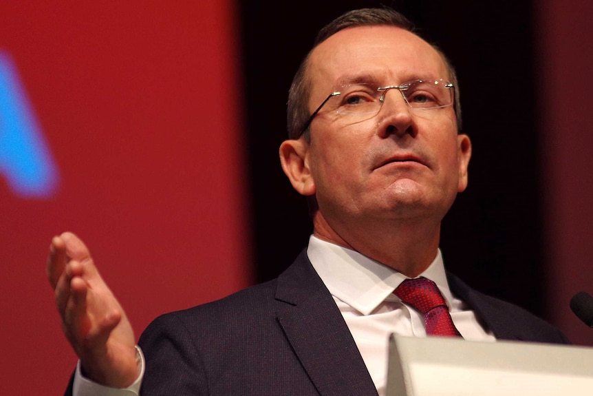 A headshot of Mark McGowan at a lectern.