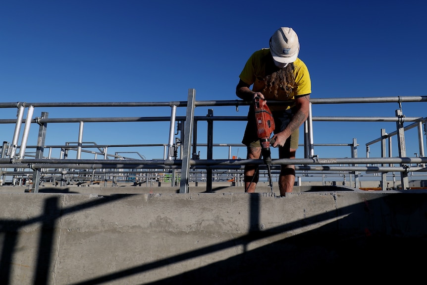 A man at a construction site with a drill.