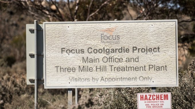 A sign on the side of the road at entrance to a gold mining operation.