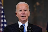 President Joe Biden speaks about efforts to combat COVID-19 from behind a podium