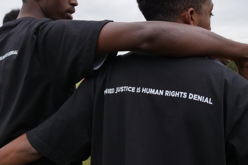 A t-shirt reads denied justice is a human rights denial