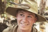 Teenage boy in khaki uniform with snake on his wide-brimmed hat