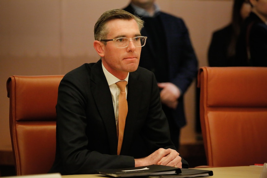 Perrottet sits with his hands folded at a table.