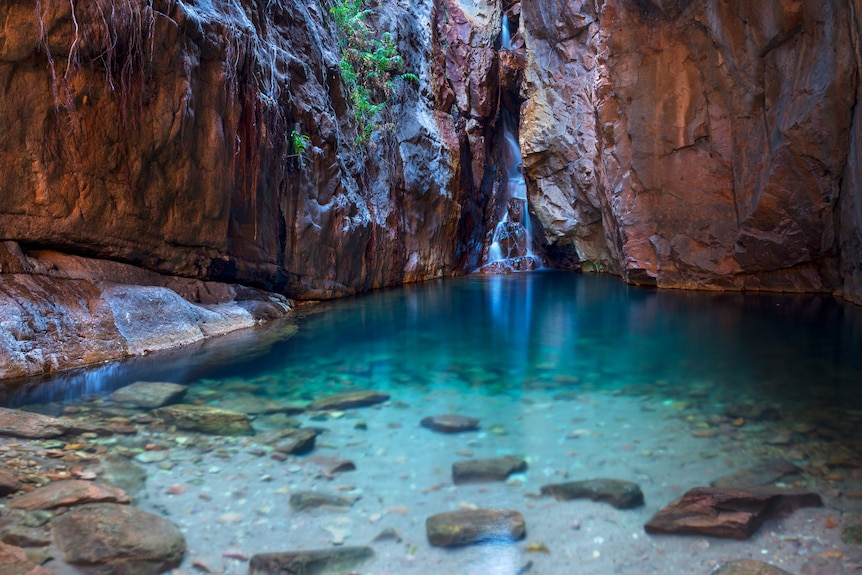 clear water cuts through a red rock chasm