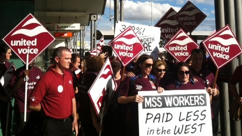 United Voice members hold signs at stopwork meeting