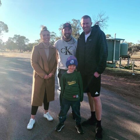 A woman standing next to two men with a young boy on a sunny day in Broken Hill