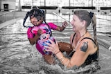 A girl in a Minnie Mouse swimsuit is lifted out of a pool by her mother. The people are in colour, background black and white