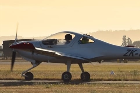A small aircraft on a runway in an airfield.