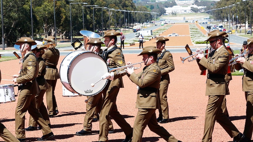 The Band of the Royal Military College march while playing their instruments.