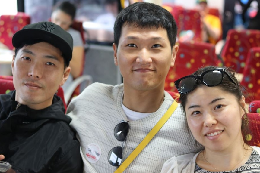 photo of three tourists sitting inside dive boat