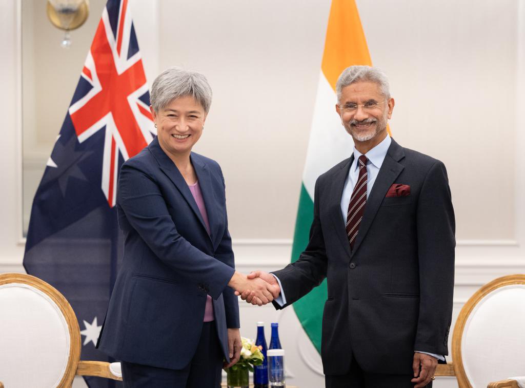 Penny Wong shakes the hand of Subrahmanyam Jaishankar with the Australian and Indian flags behind them 