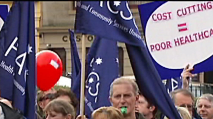 Tasmanian public servants rally outside parliament over budget cuts.