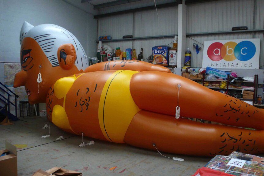 A giant balloon lays on its side in a warehouse