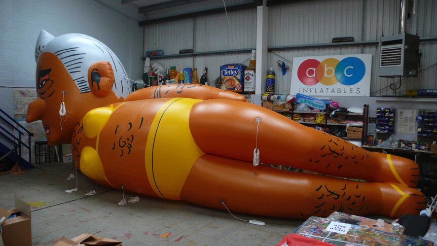 A giant balloon lays on its side in a warehouse