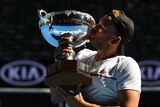 Dylan Alcott kisses the trophy after beating Andy Lapthorne in the final on Rod Laver Arena.