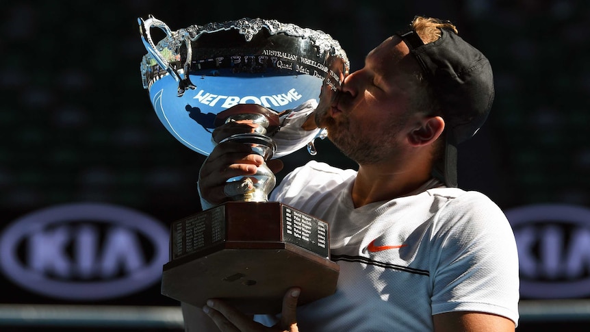 Dylan Alcott kisses the trophy after beating Andy Lapthorne in the final on Rod Laver Arena.
