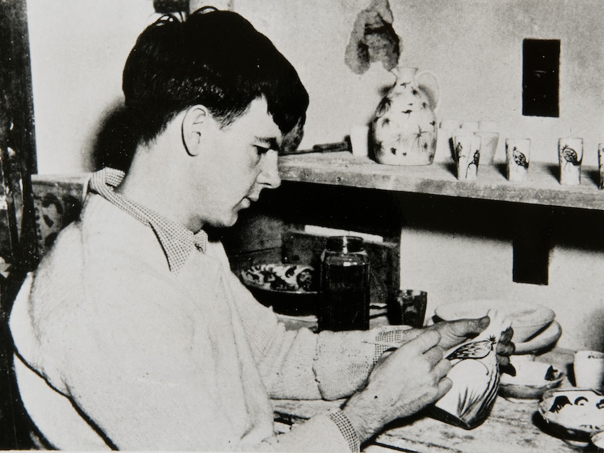 A young man making pottery in a black and white photo