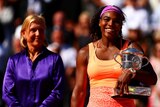 Martina Navratilova stands next to Serena Williams who holds the 2015 French Open trophy.
