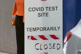 A whiteboard with the sign COVID Test Site temporarily closed