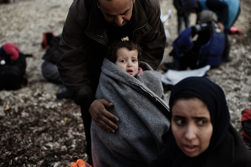 Father and daughter in Lesbos after crossing Aegean sea.