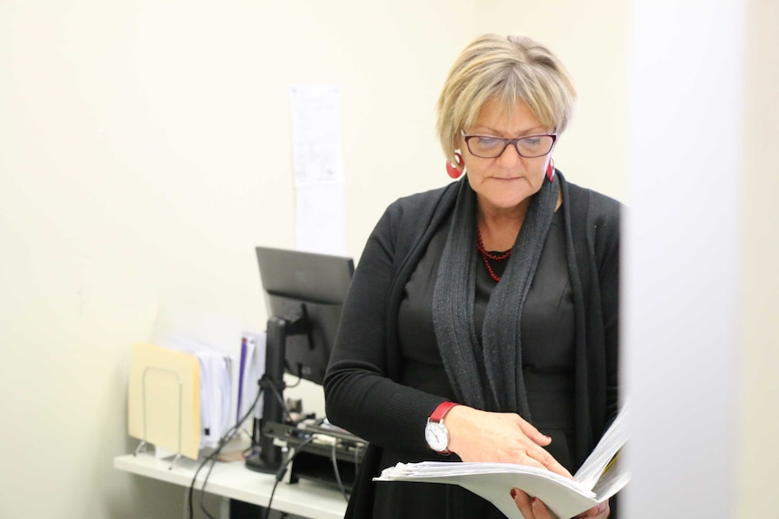 Dianne Gipey reads a document  in her office