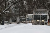 Snow plows clear a street in Brooklyn, New York City