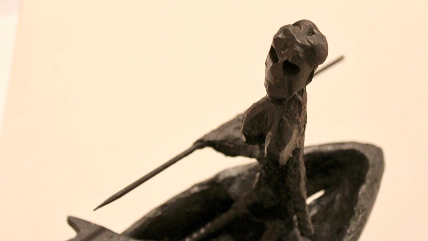 A close-up detail of a sculptural work featuring a fisherman and fisherwoman in a boat.