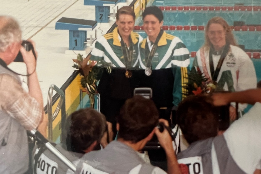 Three swimmers with their medals after a race.