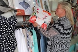 Retailer Jacqueline Major, who owns swimwear store Oz Resort, examines her stock.