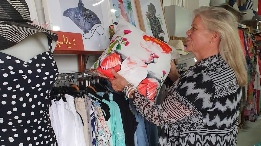 Retailer Jacqueline Major, who owns swimwear store Oz Resort, examines her stock.