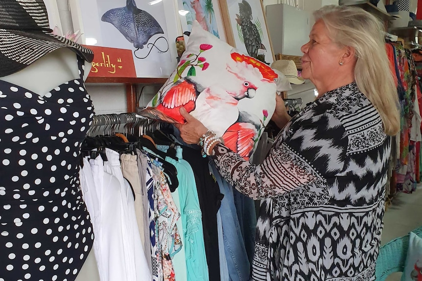 Retailer Jacqueline Major, who owns swimwear store Oz Resort, examines her stock.