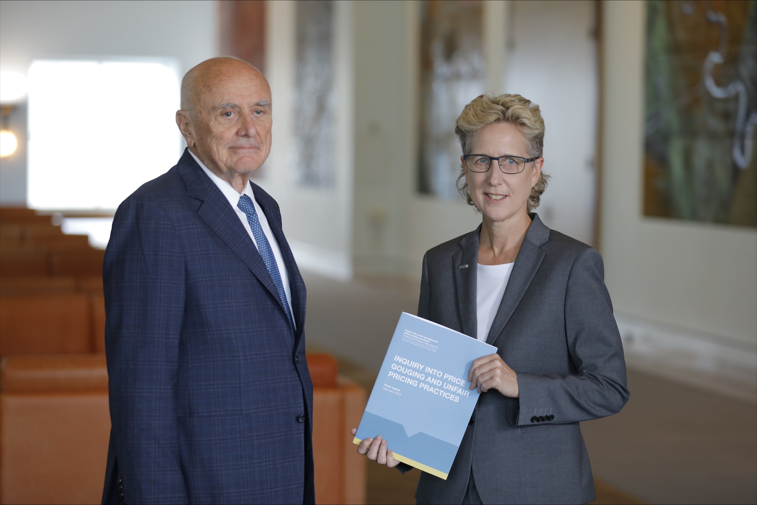 Sally McManus holding a report, standing next to Professor Allan Fels.
