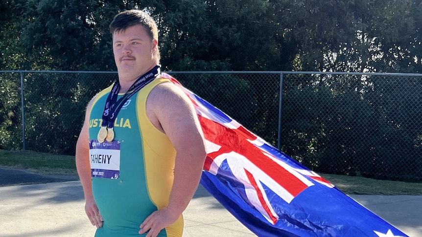 man wears Australian flag as cape