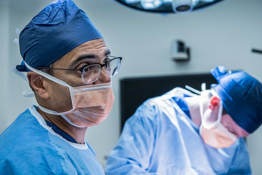 Professor Anand Deva pictured in scrubs during a breast surgery.
